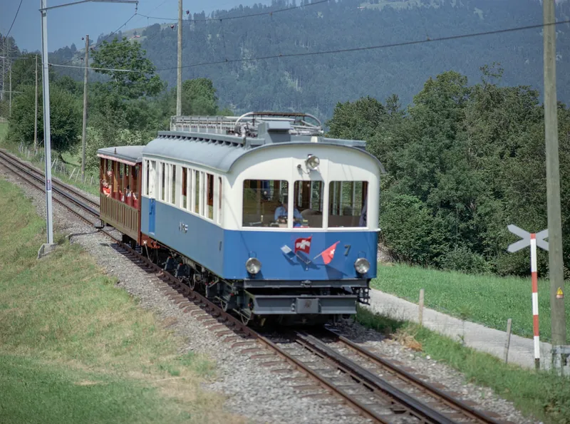 Kanton SZ, Arth, Arth-Goldau : Rigi railcar BDhe 2/4 7 on special trip for the Schwingertag on the Rigi, drive and bogie of the BDeh 2/4 7 of the Rigi-Bahn at the station ; protective line SBB Steinen-Schwyz at Km 15.770 ; Railcar BDeh 2/4 6 on the uphill run at 10:15 at Sonnenrain (Goldau) ; Railcar BDeh 2/4 13 and Bt 23 on the downhill run at 10:30 ; Vitznau-Rigi-Bahn Beh 4/4 22 and Bt 32 at Sonnenrain, downhill run at 10:32 ; Railcar BDeh 2/4 7 at 10:48 downhill run ; 11:00 uphill run of BDeh 2/4 7 ; Railcar BDeh 2/4 11 at 11.03 o'clock ; BDeh 2/4 6 in Kräbel at 11:43 on downhill ; railcar BDeh 2/4 6, a bar built in on the uphill side (13.07.2003)