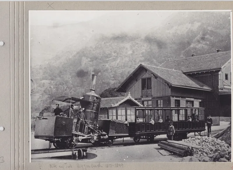 Fotografie des Rigibahn-Bahnhofs Vitznau mit SLM Lok Nr. 1 und Niklaus Riggenbach auf Lok (circa 1875)