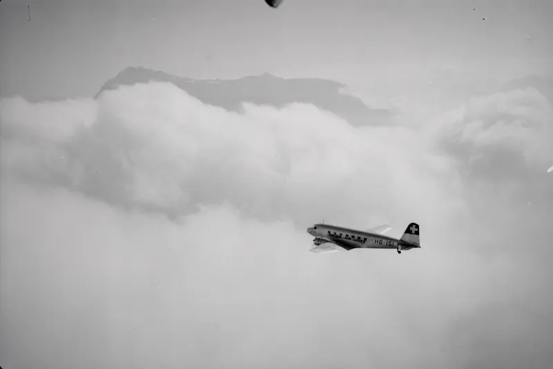 Douglas DC-2-115-D, HB-ISI in flight in the clouds in front of the Rigi, looking southeast (SE) (1935-1944)